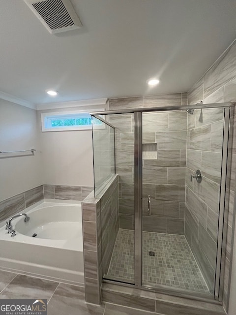 bathroom with crown molding and separate shower and tub