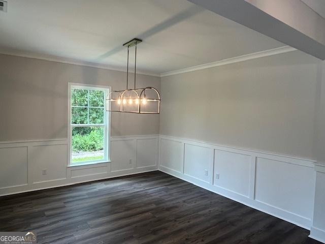 unfurnished dining area with a chandelier, dark hardwood / wood-style flooring, and crown molding