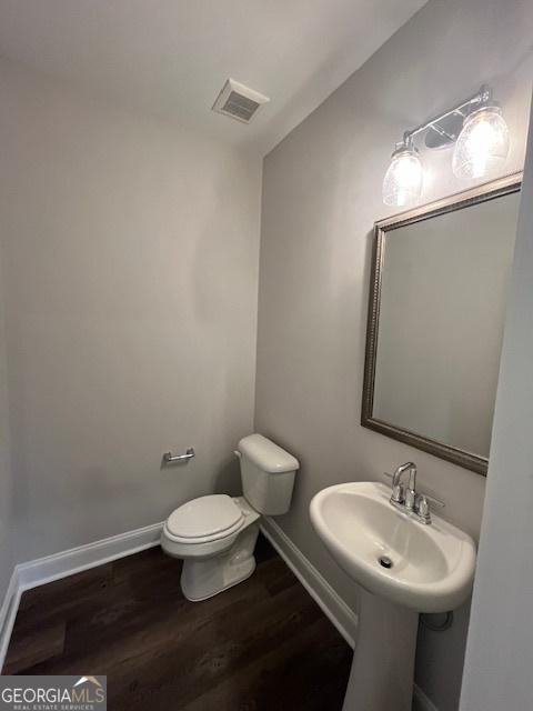 bathroom with toilet and wood-type flooring