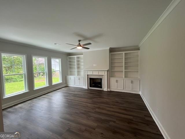 unfurnished living room with crown molding, dark wood-type flooring, and ceiling fan