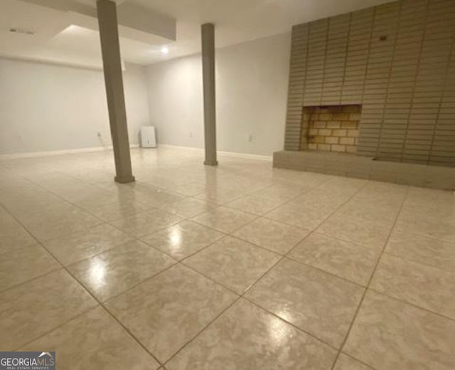 basement with brick wall and light tile flooring