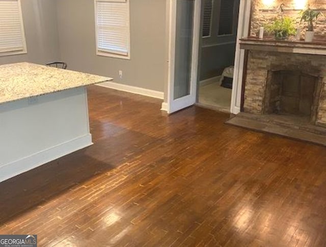 unfurnished living room featuring dark hardwood / wood-style flooring and a fireplace