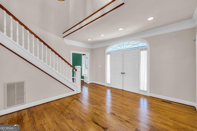 entryway featuring crown molding and hardwood / wood-style floors