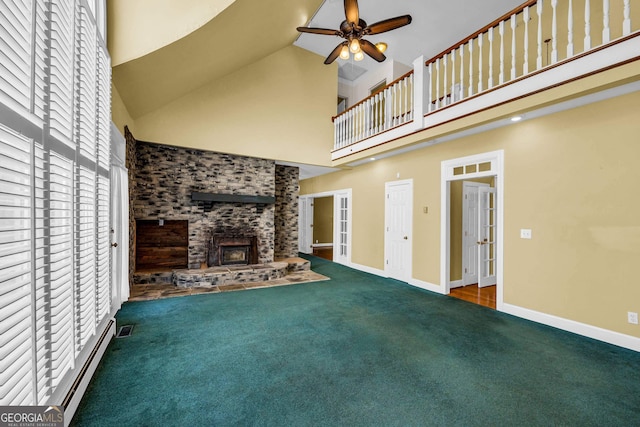 unfurnished living room featuring a brick fireplace, ceiling fan, and dark colored carpet