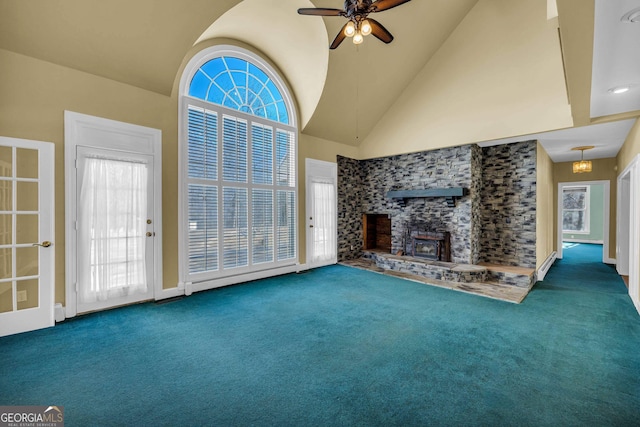 unfurnished living room featuring dark colored carpet, ceiling fan, high vaulted ceiling, and a fireplace