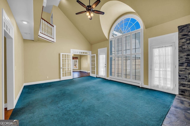 spare room with dark tile floors, high vaulted ceiling, a wealth of natural light, and ceiling fan