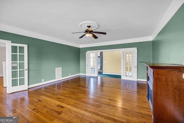 spare room with french doors, crown molding, dark wood-type flooring, and ceiling fan