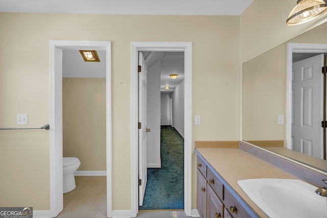 bathroom with vanity, toilet, and tile floors