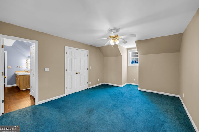 additional living space featuring ceiling fan, lofted ceiling, dark carpet, and sink