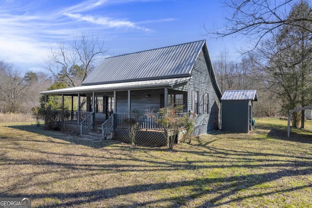 view of front facade with a front lawn, a storage unit, and a porch