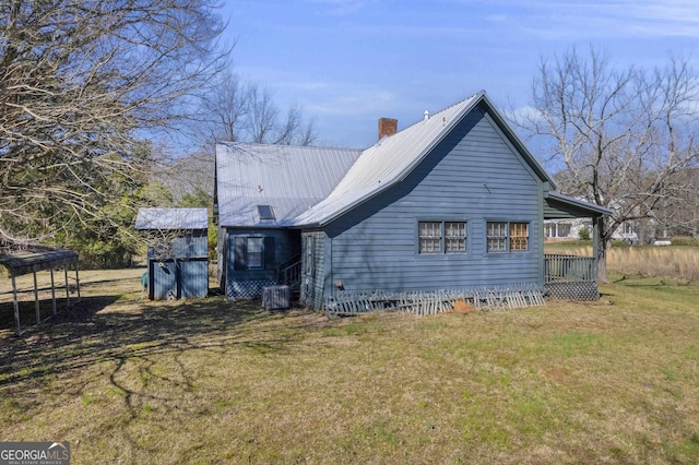 view of side of property featuring central air condition unit and a yard