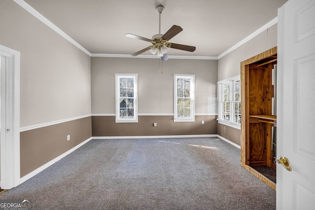 unfurnished room featuring dark carpet, ceiling fan, and crown molding