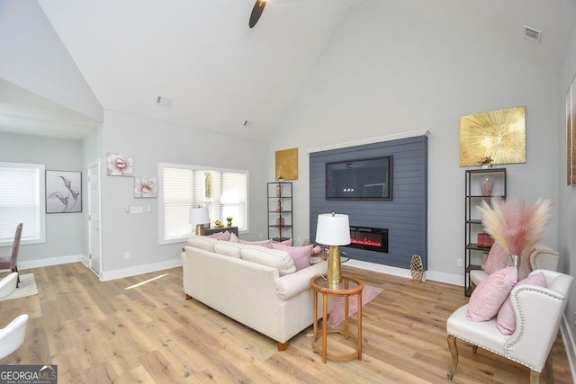 living room featuring ceiling fan, high vaulted ceiling, and light hardwood / wood-style floors