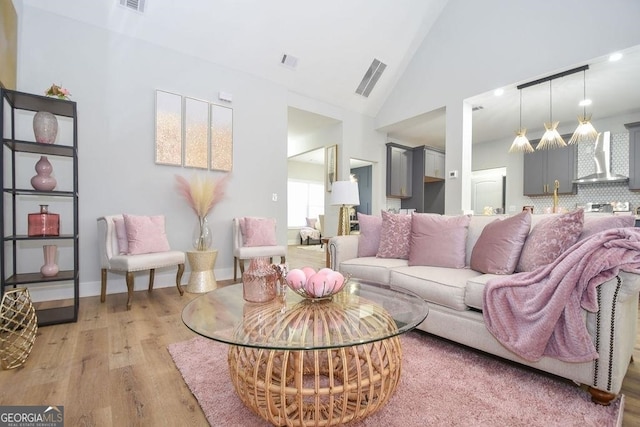 living room featuring high vaulted ceiling and hardwood / wood-style floors