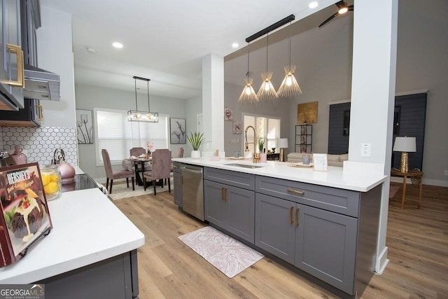 kitchen featuring pendant lighting, gray cabinetry, light hardwood / wood-style floors, dishwasher, and sink