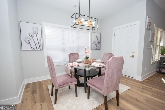 dining area featuring light hardwood / wood-style flooring and an inviting chandelier