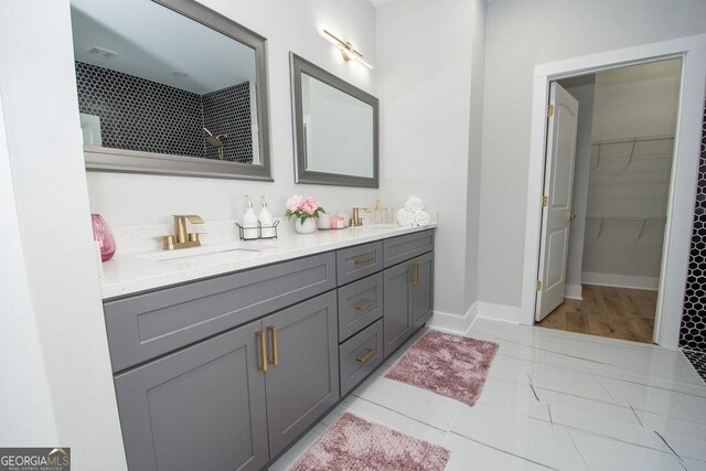 bathroom featuring dual sinks, large vanity, and hardwood / wood-style flooring