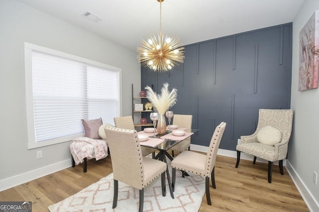 dining room with a notable chandelier and light wood-type flooring