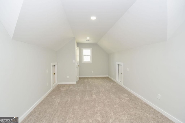 additional living space with lofted ceiling and light carpet