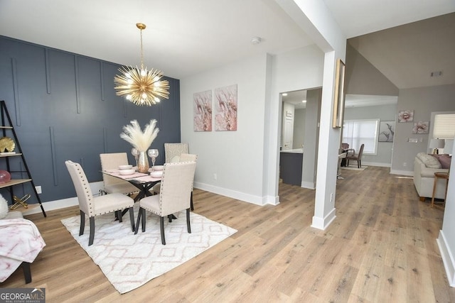 dining space featuring a notable chandelier and light wood-type flooring