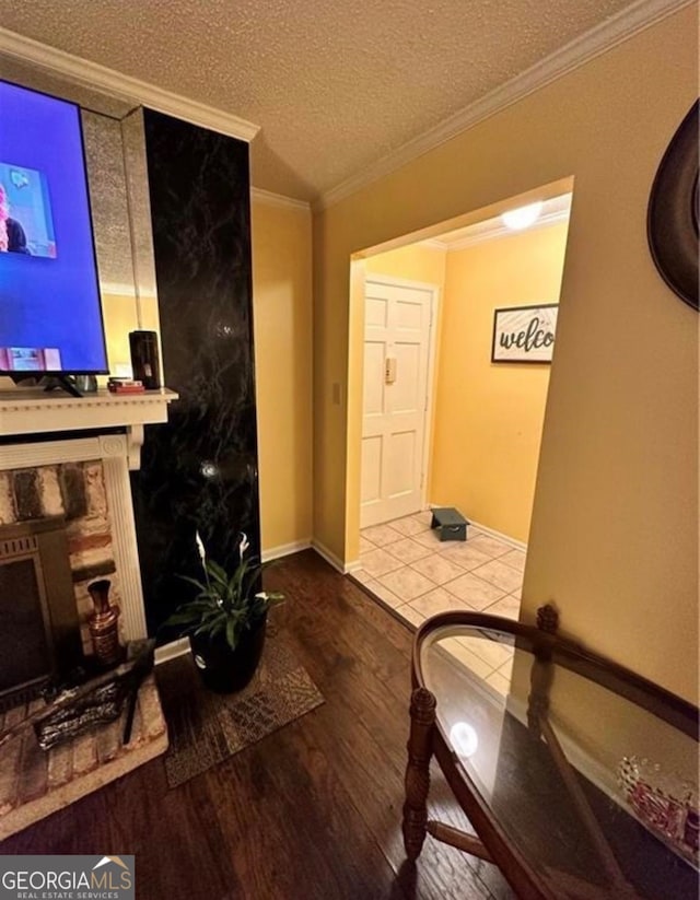 interior space with a textured ceiling, wood-type flooring, and ornamental molding