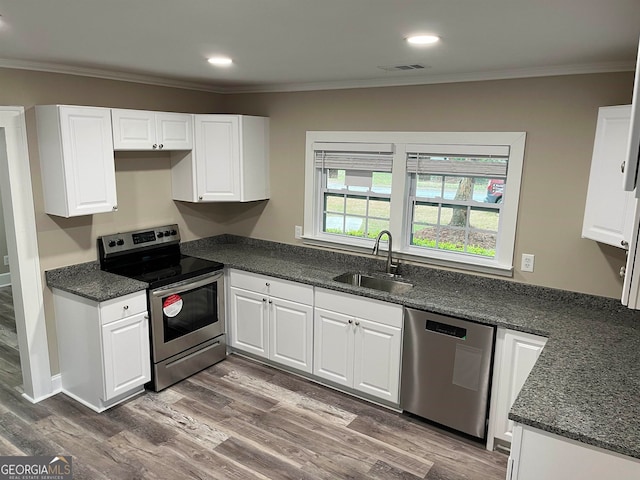 kitchen featuring hardwood / wood-style flooring, white cabinetry, sink, and stainless steel appliances