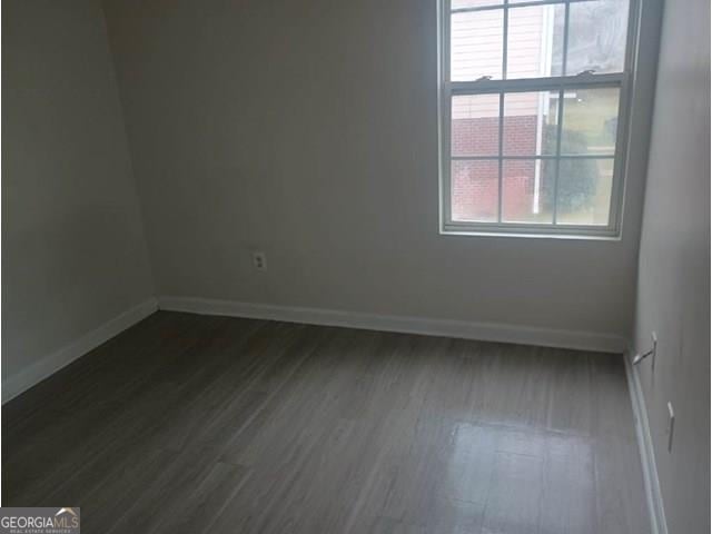 unfurnished room with dark hardwood / wood-style flooring