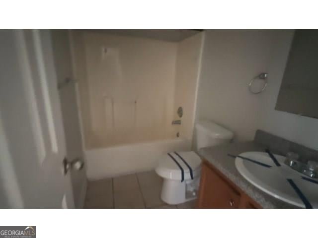 full bathroom featuring shower / washtub combination, toilet, tile floors, and vanity