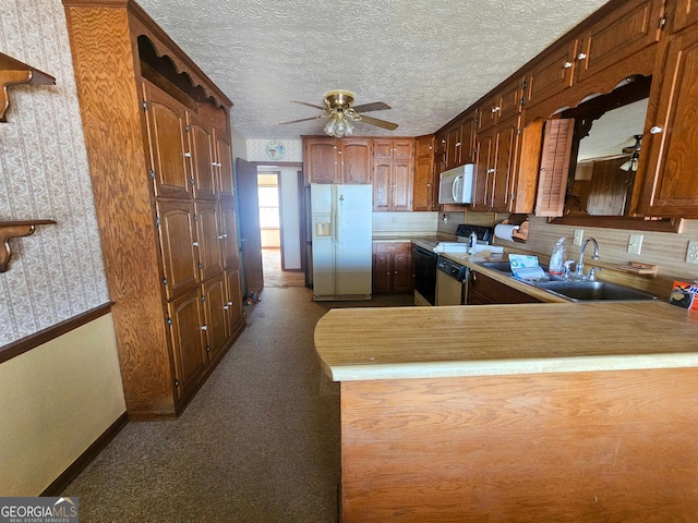 kitchen featuring white appliances, a textured ceiling, ceiling fan, and sink