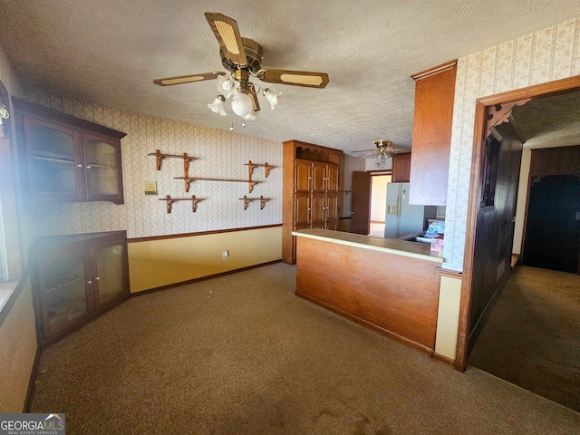 kitchen with stainless steel fridge with ice dispenser, a textured ceiling, dark carpet, and ceiling fan