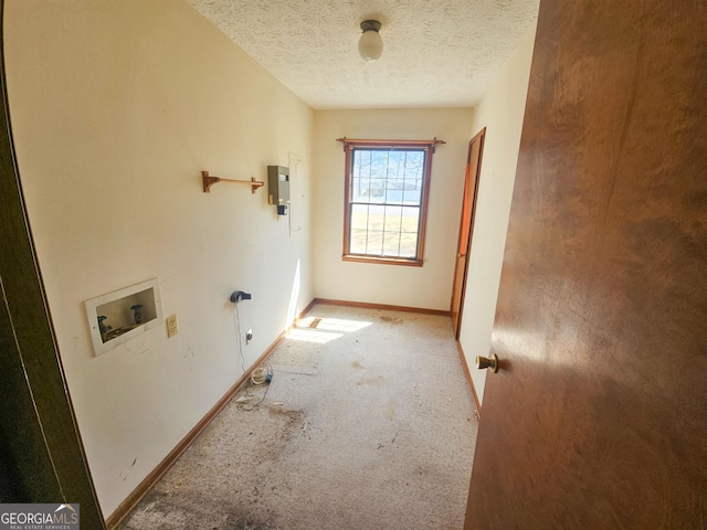 interior space with a textured ceiling, washer hookup, and light colored carpet