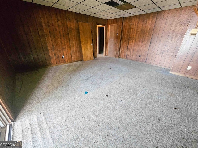 empty room featuring a drop ceiling and carpet flooring