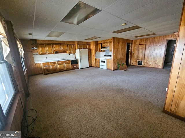 unfurnished living room with carpet floors and a drop ceiling