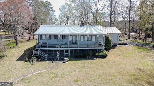 rear view of property with covered porch and a lawn