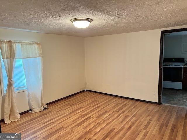 empty room featuring a textured ceiling and light wood-type flooring