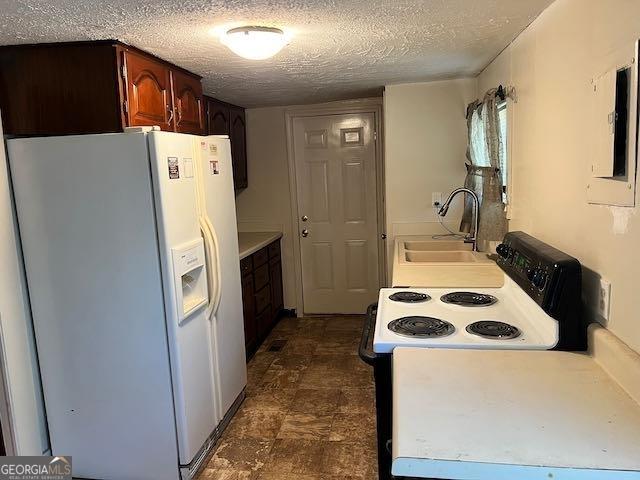 kitchen with sink, white fridge with ice dispenser, a textured ceiling, and range with electric cooktop