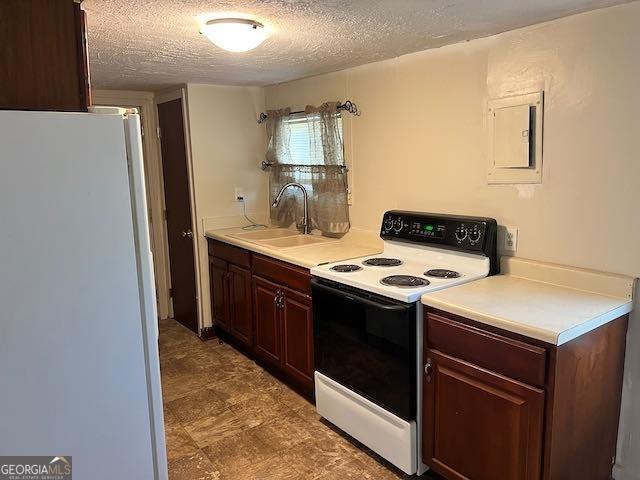 kitchen featuring white fridge, a textured ceiling, sink, and electric range oven