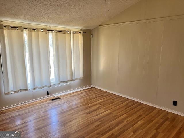 spare room featuring a textured ceiling and hardwood / wood-style floors