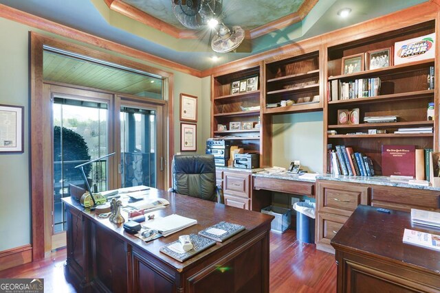 office area with a raised ceiling and dark hardwood / wood-style flooring