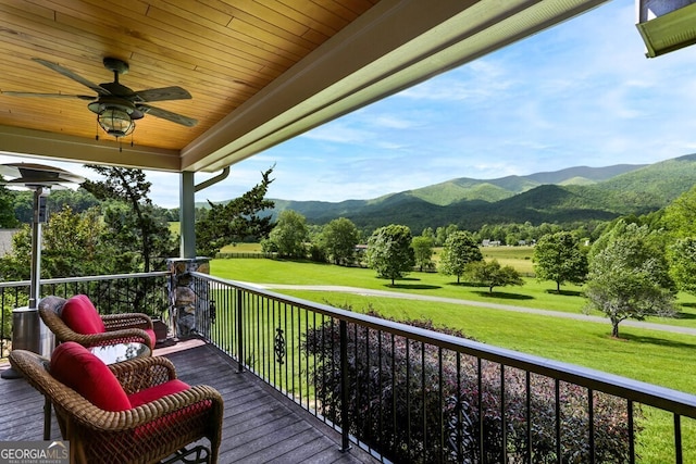 exterior space with a mountain view, a yard, and ceiling fan