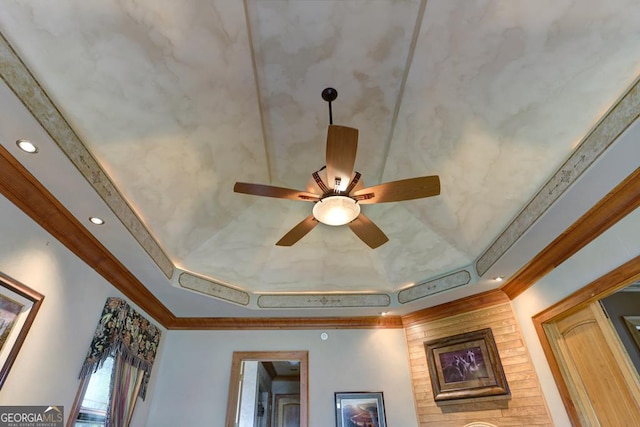 interior details with crown molding, ceiling fan, and a raised ceiling