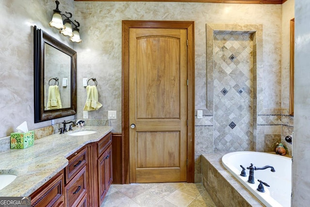 bathroom featuring tiled tub and vanity