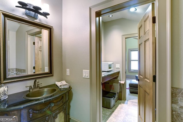 bathroom featuring tile patterned floors, vaulted ceiling, and vanity