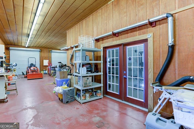 miscellaneous room featuring concrete flooring, wooden walls, and french doors