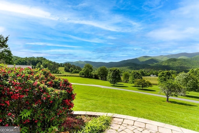 surrounding community with a yard and a mountain view