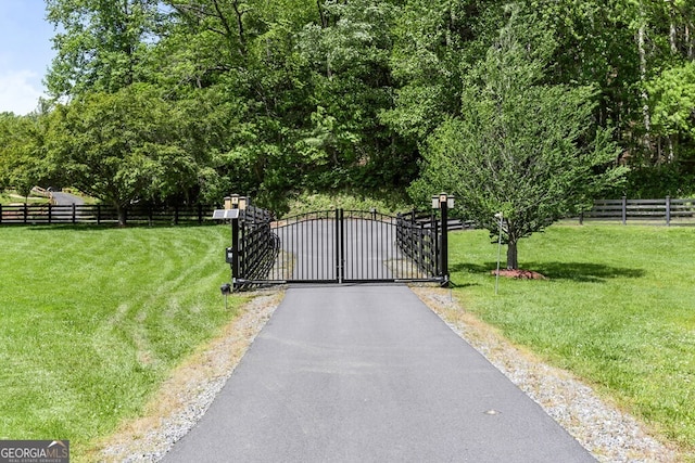 view of gate with a lawn