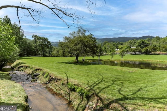 surrounding community featuring a lawn and a water and mountain view