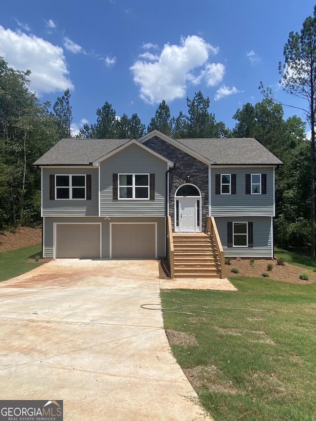 bi-level home with a garage and a front lawn