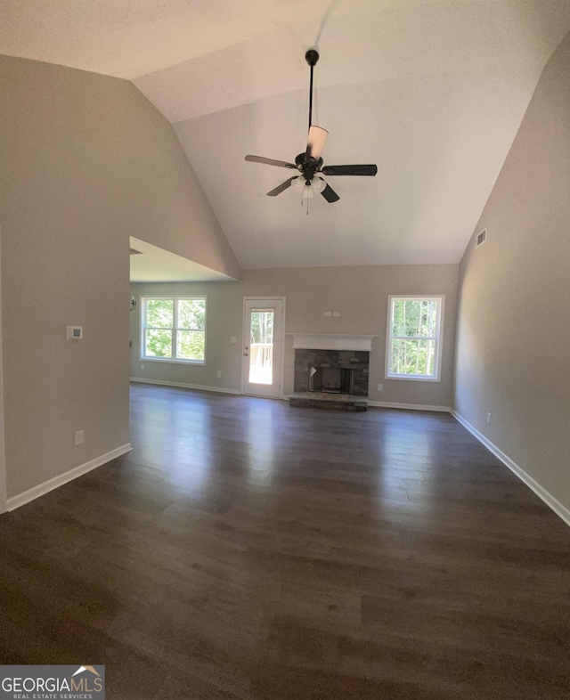 unfurnished living room with ceiling fan, a fireplace, baseboards, and a healthy amount of sunlight