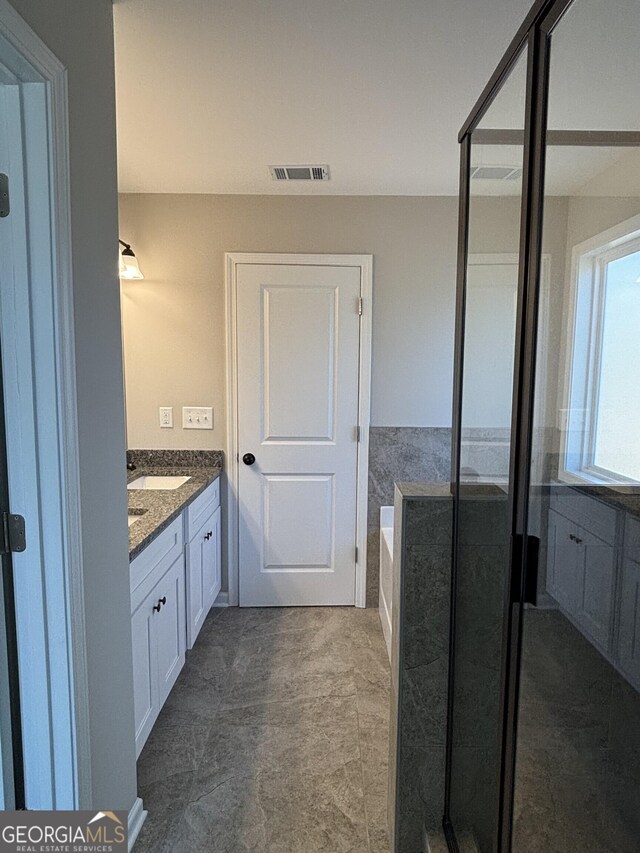 bathroom featuring visible vents, vanity, a shower stall, and a bath